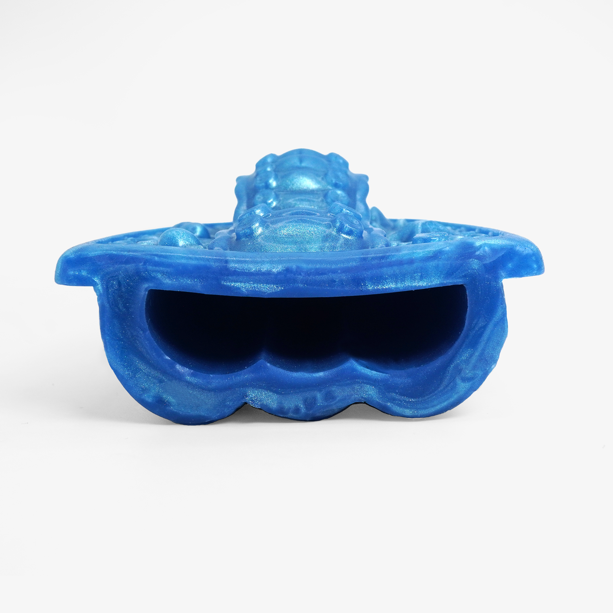 The handheld tentacle grinder ii laying down with finger hole.